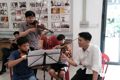 Anh Nguyễn Trung Đức (chủ nhiệm Câu lạc bộ Hội Những người yêu thích violin, bìa phải) hướng dẫn các em nhỏ học đàn miễn phí