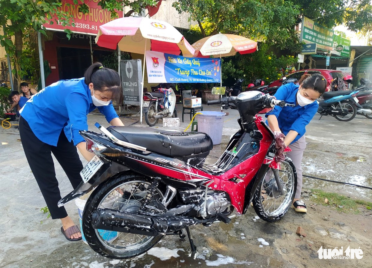 Nghỉ lễ, các cô gái trẻ xắn tay áo rửa xe gây quỹ cho trẻ em nghèo